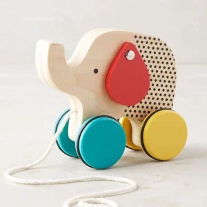 **Alt Text:** Wooden elephant pull-along toy with colorful wheels and a rope handle, designed for toddlers to encourage walking and imaginative play.
